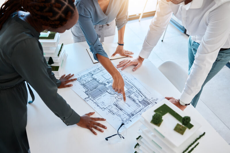 Profesionales revisando planos y maquetas durante un estudio HBU para definir el mejor uso y valor de una propiedad.